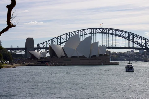 A large white building with a bridge in front of it.